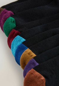 Schwarze Socken mit kontrastfarbenen Zehenakzenten in Grün, Lila, Burgunderrot, Blau, Türkis und Braun, mit glatter Textur.