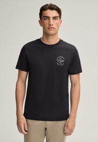 T-shirt noir en coton à manches courtes avec col rond, impression sur la poitrine, et coupe ajustée. Texture lisse et design classique.