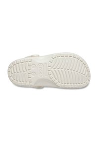 Light-colored rubber sandal sole with textured tread pattern, including grooves and bumps for grip. Features minimal detailing and logo.