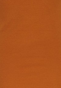 Ribbad orange textil med en mjuk textur, jämn färg och fina vertikala linjer, lämplig för kläder eller möbelklädsel.