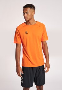 Korte mouwen sportshirt in feloranje met een textuurdesign, voorzien van een logo op de borst en contrasterende grijze accenten op de schouders.