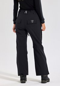 Zwarte cargobroek met meerdere zakken, elastische tailleband en ritsen bij de enkel. Gemaakt van duurzame, flexibele stof.