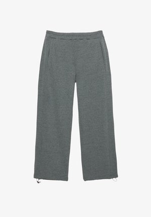 Grå sweatpants med en afslappet pasform, der har sidelommer og justerbare snore i kanten. Glat, let stoftexture.