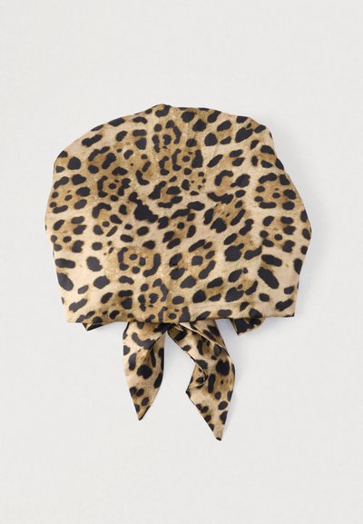 Φουλάρι με μοτίβο λεοπάρδαλης σε μπεζ και μαύρο, κατασκευασμένο από απαλό ύφασμα, με κορδόνια στο κάτω μέρος για δέσιμο ή στιλάρισμα.