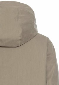 Beige Kapuzenjacke mit glatter Textur, Nahtdetails und lässigem Design. Verfügt über einen hohen Kragen und klare Linien.