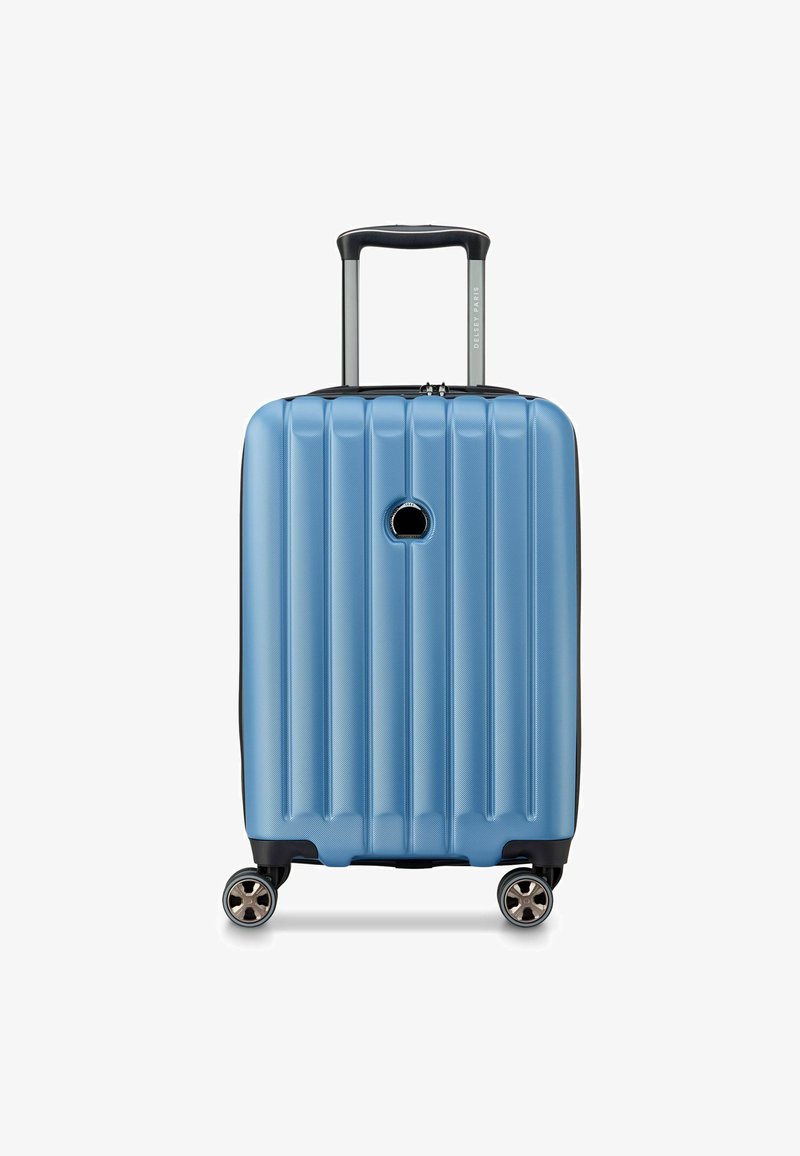 Valigia rigida di colore azzurro chiaro, con scanalature verticali, manico retrattile, quattro ruote piroettanti e un bordo nero lungo la base.
