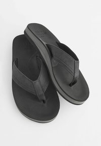 Sorte flip-flops med strukturerede stropper, polstret sål og en let hæl. Har et minimalistisk design med perforerede detaljer.