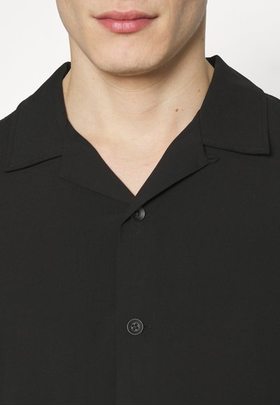 Schwarzes Kurzarmhemd mit Schalkragen, einer Knopfleiste und glatter Textur. Es hat ein minimalistisches Design ohne Muster.