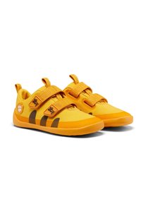 Gele sportschoenen met twee klittenbandsluitingen, voorzien van een textiel bovenwerk en een rubberen zool, afgewerkt met bruine strepen.