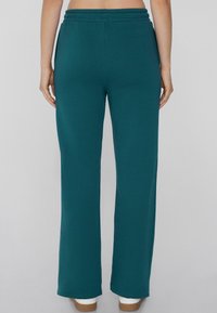 Türkise weit geschnittene Hose mit elastischem Bund, aus weichem Stoff gefertigt. Sie verfügt über einen nahtlosen Rücken und einen geraden Schnitt, ideal für die Freizeit.