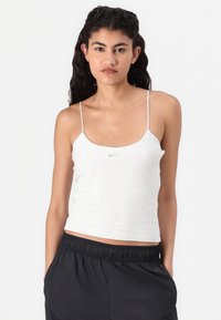 Top ajustado cinza claro com alças finas e decote em forma de barco. Apresenta um pequeno logótipo da Nike no peito. Material suave com textura lisa.