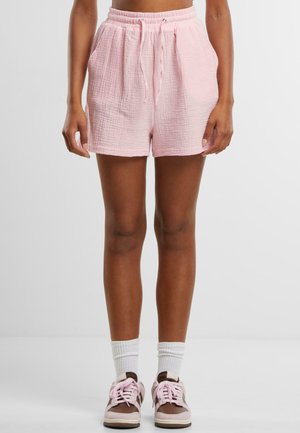 Shorts din bumbac texturat, roz deschis, cu talie elastică și șnur. Buzunare frontale și croială lejeră. Asortați cu adidași maronii și șosete albe.
