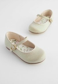 Zapatillas de ballet doradas brillantes con punta redondeada, correa y hebilla decorativa. Plantilla con patrón floral y borde ondulado. Textura suave.