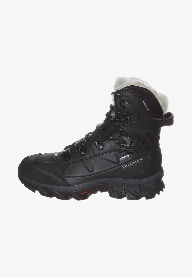 Bota de senderismo negra con parte superior de cuero texturizado, forro de piel sintética, sistema de cordones reforzado y suela de goma resistente para un buen agarre.