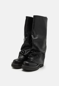 Bottes noires jusqu'aux genoux en matériau synthétique brillant avec un design décontracté, bout rond et semelle épaisse en caoutchouc texturé.