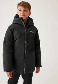 Veste rembourrée à capuche noire avec fermeture éclair, arborant un grand patch logo et un design de panneaux contrastants. Texture lisse et coupe décontractée.