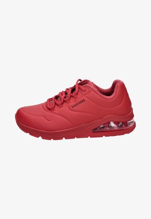 Scarpe sportive rosse con tomaia sintetica liscia, accenti perforati, chiusura con lacci e suola trasparente ammortizzata.
