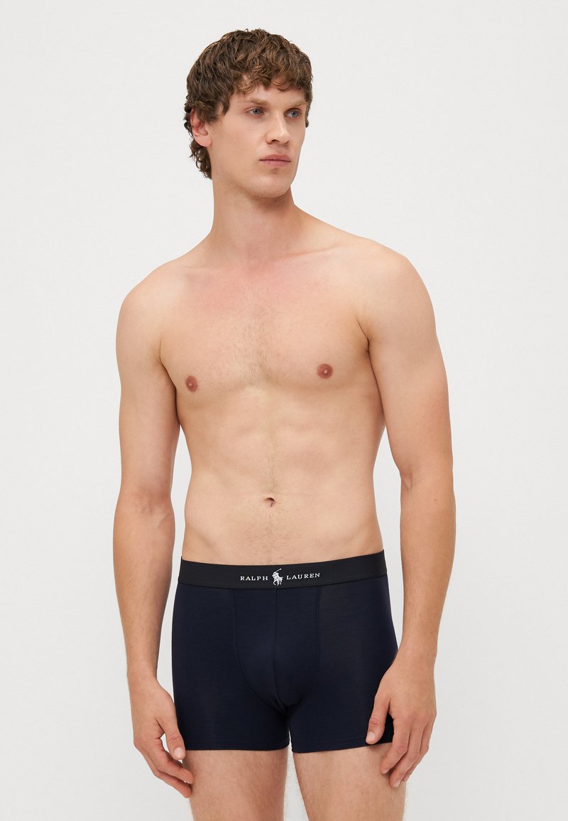 Marineblauwe boxershorts met een zachte textuur, voorzien van een zwarte tailleband met een wit logo. Ontworpen voor een strakke pasvorm en comfort.