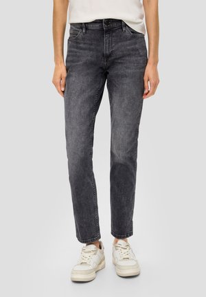 Dunkelgraue Denim-Jeans mit geradem Bein, Five-Pocket-Design und subtilen Abriebstellen, kombiniert mit weißen Turnschuhen.