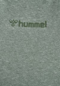 Green sweatshirt with a textured finish. Features a dark green "hummel" logo printed on the front. Soft, comfortable fabric.