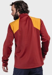 Roter Pullover mit langen Ärmeln und gelben Schulterakzenten, hohem Kragen, glatter Textur und tailliertem Design. Die Rückansicht zeigt die Nahtdetails.