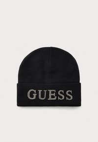 Svart strikket lue med brettet kant, prydet med ordet "GUESS" stavet med sølvfargede rhinestones på forsiden.