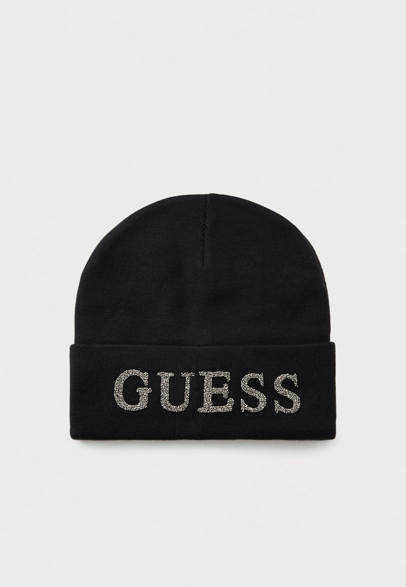 Svart strikket lue med brettet kant, prydet med ordet "GUESS" stavet med sølvfargede rhinestones på forsiden.