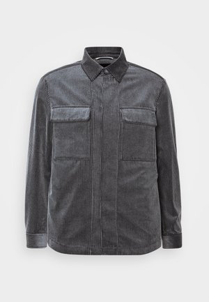Black and gray striped corduroy shirt with a button-down collar, two chest pockets, and long sleeves. Textured fabric with a smooth finish.