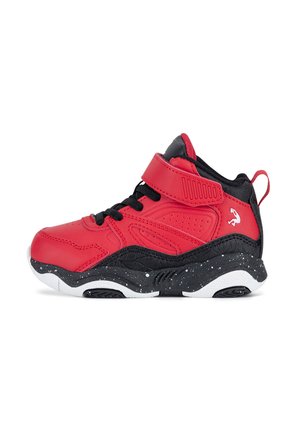 Baskets montantes rouges et noires avec lacets noirs, une sangle rouge en velcro, semelle blanche tachetée et un petit logo blanc sur la zone du talon.