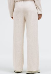 Beige wide-leg sweatpants made of soft fabric with a smooth texture. The waistband sits comfortably and has a clean, minimal design.
