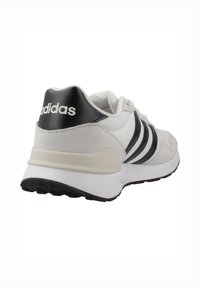 Deportivas blancas con acentos en gris y negro, que cuentan con tres franjas negras, una parte superior texturizada y una suela acolchada para mayor comodidad.