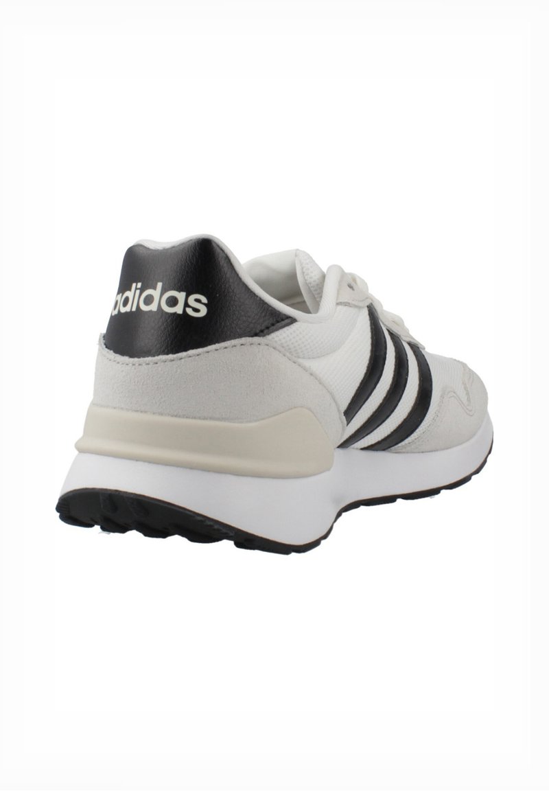 White athletic shoe with grey and black accents, featuring three black stripes, a textured upper, and a cushioned sole for comfort.