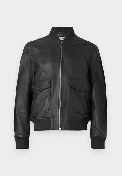 Chaqueta bomber de cuero negro con cierre de cremallera, puños acanalados y dos bolsillos frontales. Textura suave y diseño estructurado.