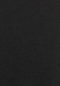 Czarna żeberkowana tkanina, charakteryzująca się jednolitą teksturą z pionowymi liniami, tworząc gładką, elastyczną powierzchnię idealną do odzieży.