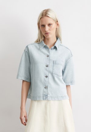 Lichtblauwe denimshirt met een kraag, korte mouwen, knopen aan de voorkant en een borstzak. De stof heeft een zachte, gestructureerde uitstraling.