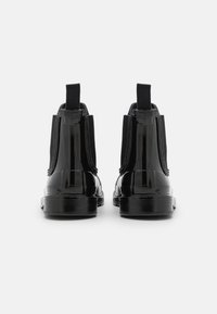 Zwarte gepatineerde leren enkelboots met elastische zijpanelen en trek- katoen, met een gladde en glanzende afwerking en een stevige rubberen zool.