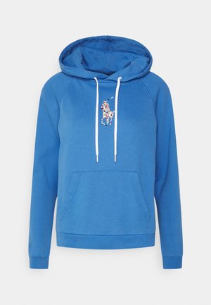 Sininen huppari, jossa valkoiset kiristysnauhat, etukangaroo-tasku ja värikäs geometrinen polo-pelaajan logo rinnan keskellä.