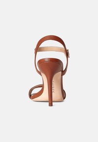 Brown leather high-heeled sandal with a thin stiletto heel, adjustable ankle strap, and open toe design, featuring a smooth texture.