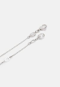 Cadena de plata que cuenta con un cierre de langosta, enlaces octogonales y circulares, con un acento de gema clara engastado en un bisel facetado.