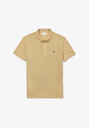 Beżowa koszulka polo z teksturowanej tkaniny, z trzema guzikami na plastrze i haftowanym logo Lacoste na lewej piersi. Krótkie rękawy.