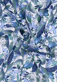 Tessuto di cotone con un motivo floreale caratterizzato da foglie e fiori blu e verdi su uno sfondo bianco, dettagliato con trame intricate.