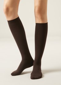 Kniestrümpfe aus einem festen, dunkelbraunen Stoff, die eine glatte Textur und ein geripptes Oberband aufweisen. Geeignet für verschiedene Outfits.