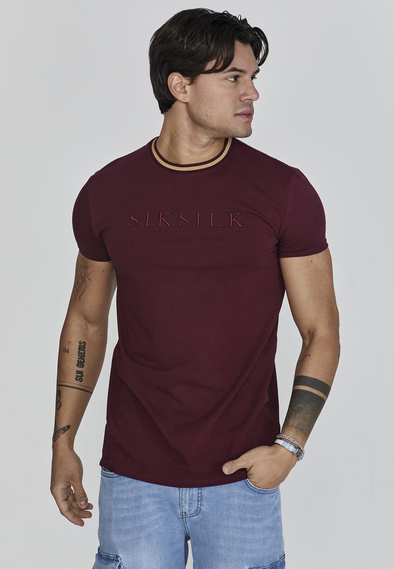 Bordowa koszulka z krótkim rękawem z żebrowanym okrągłym dekoltem i wytłoczonym logo "SIKSILK". Zaprojektowana w dopasowanym kroju, wykonana z miękkiej bawełny.