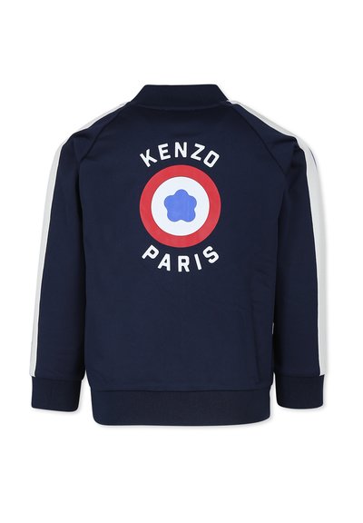 Veste bleu marine avec des rayures blanches sur les côtés, présentant un graphique circulaire rouge et blanc à l'arrière. Le texte indique "KENZO PARIS". Tissu doux.