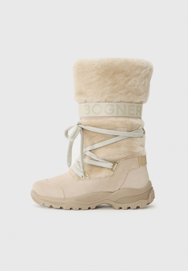 Bota de invierno color crema con un puño esponjoso, cordones y una suela resistente. Presenta un sutil logo de la marca en la banda.