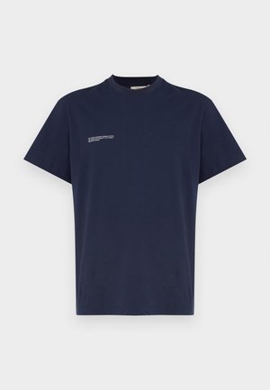 Tricou din bumbac de culoare bleumarin, cu guler rotund, mâneci scurte și un detaliu mic din text alb pe pieptul stâng. Textură netedă.