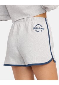 Grijze sweatshorts met een zachte textuur, voorzien van een marineblauwe bies en zijslits. 'Billabong'-logo geborduurd in marineblauw op de achterkant.