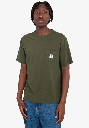 Olive green short-sleeve T-shirt with a chest pocket, made of cotton, featuring a small brand label on the pocket, paired with blue denim jeans.