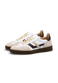 Weiße und beige Turnschuhe aus Wildleder und Leder, mit abgerundeter Zehenform, beigen Schnürsenkeln sowie braunen Akzenten an den Seiten und der Ferse.