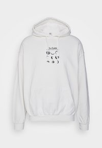 Vit bomullshuvtröja med en frampocket, dragsko i huvan och ett tryckt mönster med månens faser och text på bröstområdet.